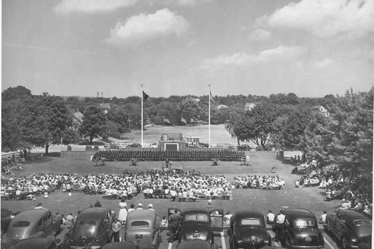 Photo of class of 1949 Graduation Ceremony at Ralph Talbot Amphitheatre. Photo view from hill looking down towards Middle Street. Onward Fourtyniners in forground in front of podium. Image provided by: Jodi Purdy-Quinlan, Vice Chairman of the Weymouth Historical Commission