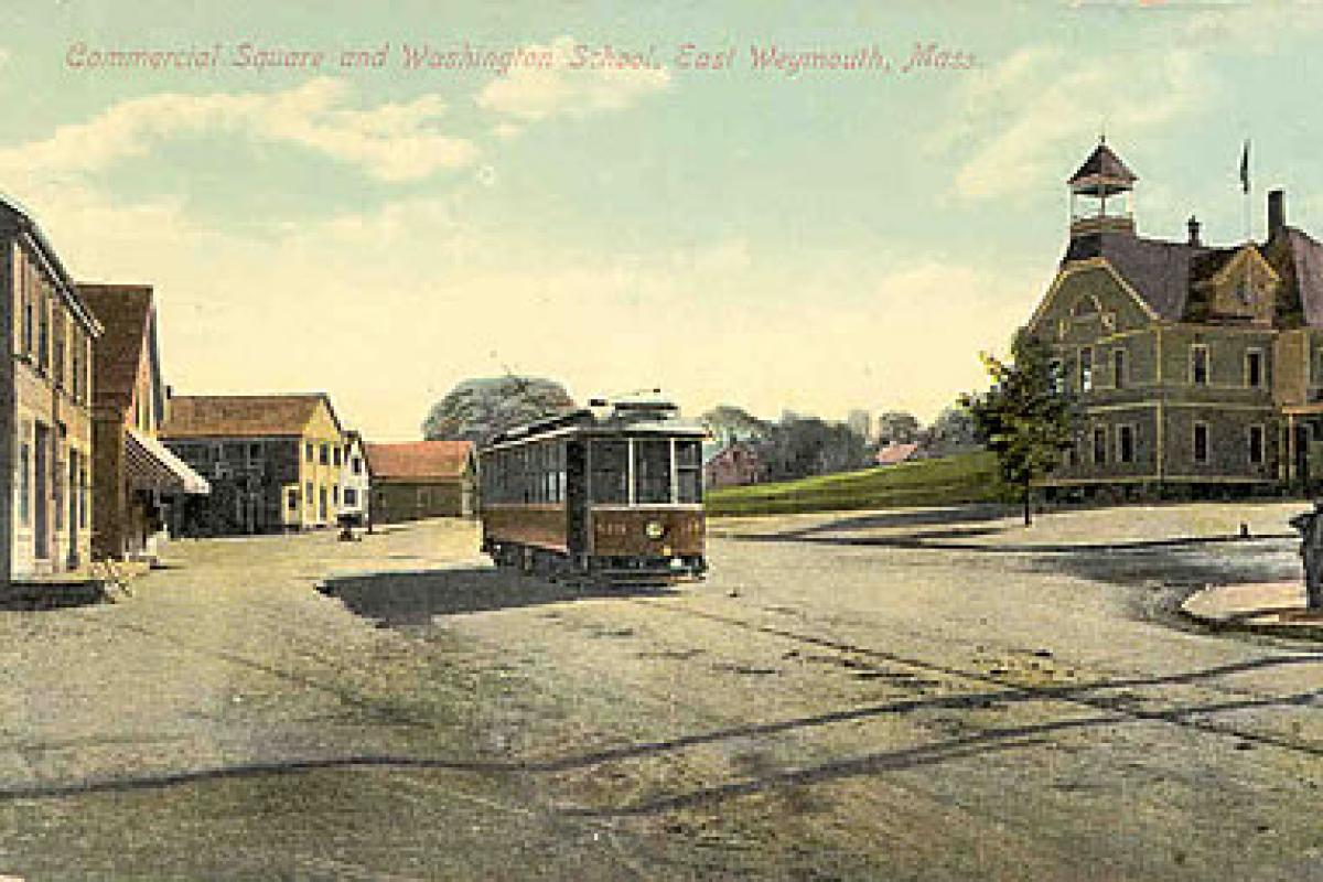Postcard of Lower Jackson Square. Washington School Building is on the right hand side of the card. Today that building is still standing and restored and used as office space. The awning on the left hand side was the entrance to Burrell's which was a long time business in Lower Jackson Square. Burrell's is currently Nico's Restaurant. Image provided by the William and Elaine Pepe postcard collection.